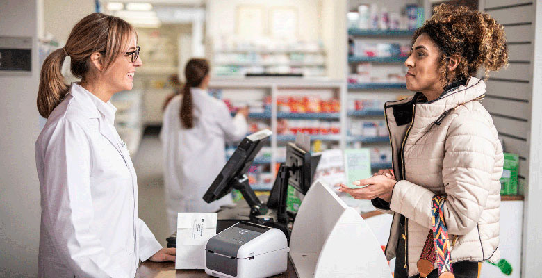 Farmaceut razgovara sa kupcem na šalteru sa Brother TD desktop štampačem